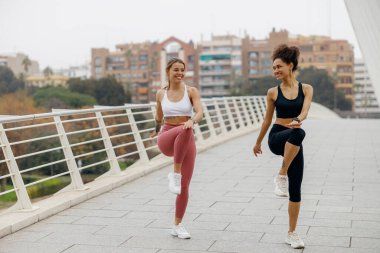 Aktif kadınlar sabah koşmadan önce kardiyo egzersizleri yaparlar. Sağlıklı fitness