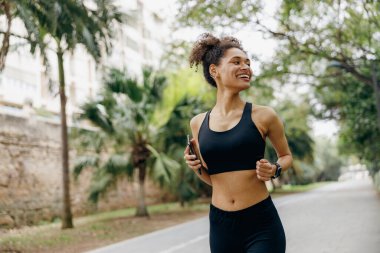 Aktif kadın sporcu sabah doğal park arka planında koşuyor. Sağlıklı yaşam konsepti