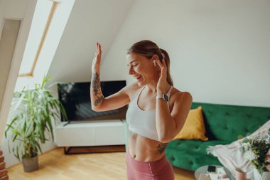 Mutlu kadın, oturma odasındaki ahşap zeminde zarif bir şekilde dans ediyor.