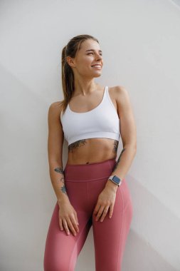 Spor giyim sektöründe bayan sporcu sabah koşusundan sonra dinleniyor ve başını çeviriyor.
