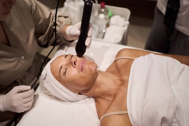Parlak cilt ve derin rahatlama için gelişmiş araçlar kullanan huzurlu bir spa yüz tedavisi deneyin