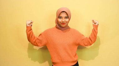 Heyecanlı Asyalı kadın yanındaki fotokopi alanını işaret ediyor, beyaz arka planla izole edilmiş.