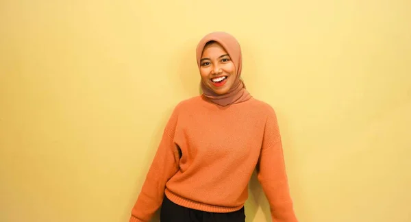 Ενθουσιασμένη Ασιάτισσα Μουσουλμάνα Που Φορούσε Πορτοκαλί Πουλόβερ Και Χιτζάμπ Δείχνοντας — Φωτογραφία Αρχείου