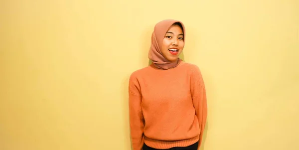 Возбужденная Азиатская Мусульманка Оранжевом Свитере Хиджабе Указывает Пространство Рядом Ней — стоковое фото