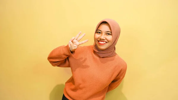 Opgewonden Aziatische Moslim Vrouw Draagt Oranje Trui Hijab Wijzend Kopieerruimte — Stockfoto