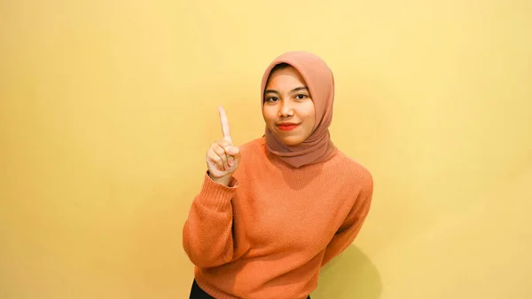 Podekscytowana Muzułmanka Azjatycka Pomarańczowym Swetrze Hidżab Wskazujący Miejsce Obok Niej — Zdjęcie stockowe