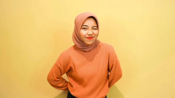 Захоплена Азіатська Мусульманка Одягнена Помаранчевий Светр Хіджаб Вказує Копіювальний Простір — стокове фото