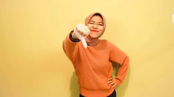 指を使って違う方向を指差してる若いアジアの女性孤立したオレンジの背景の上に空白コピースペースが立ってる 指を指してる 方向性を与える — ストック写真