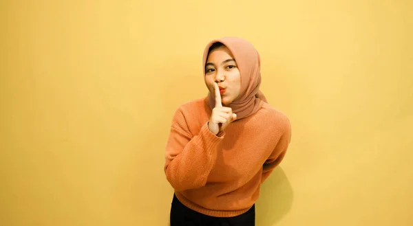 年轻的亚洲女人用手指指向不同的方向 在孤立的橙色背景之上留有空白的复制空间 指指点点指明方向 — 图库照片