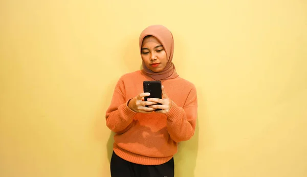 Νεαρή Όμορφη Ασιατική Γυναίκα Φορώντας Πορτοκαλί Πουλόβερ Χρήση Smartphone Απομονώνονται — Φωτογραφία Αρχείου