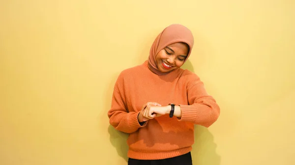 Potret Seorang Gadis Muda Tersenyum Mengenakan Sweater Oranye Melihat Jam — Stok Foto