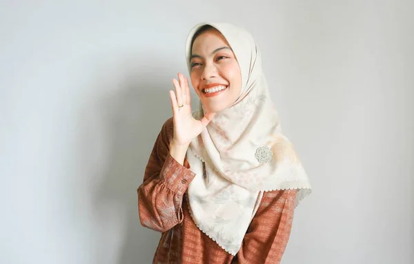 白い背景に孤立した彼女の口の上に手で大声で叫んで叫んで大声でスカーフを身に着けている若い美しいアジアのイスラム教徒の女性 コミュニケーションの概念 — ストック写真