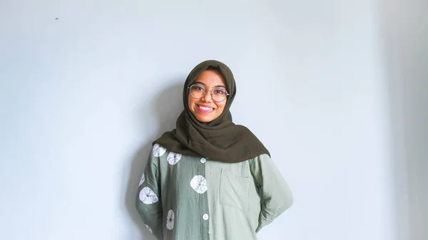 身穿睡衣和头巾的兴奋的亚洲穆斯林妇女指着身边被白色背景隔开的复制空间 — 图库照片