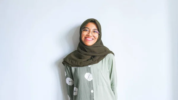 身穿睡衣和头巾的兴奋的亚洲穆斯林妇女指着身边被白色背景隔开的复制空间 — 图库照片