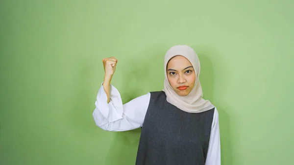 工作室的肖像照片年轻的亚洲妇女使用的休闲衫与愤怒的脸的绿色背景 年轻女性面对表情肖像的概念 — 图库照片