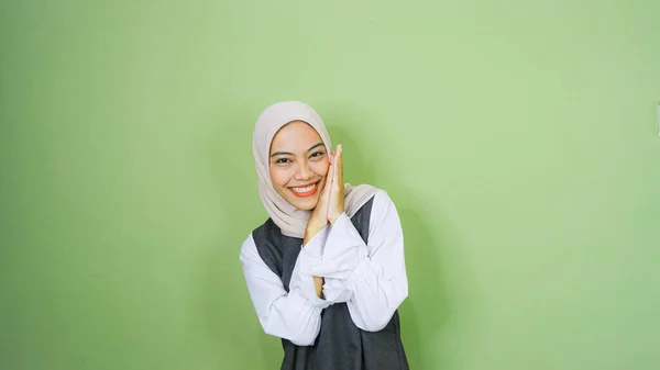 快乐的亚洲穆斯林女人 穿着休闲装 头戴头巾 指着旁边被绿色背景隔开的复制空间 — 图库照片
