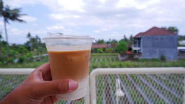 Balkonda plastik bir fincanda buzlu kahve, stok fotoğrafı.