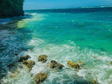Kayalar ve turkuaz deniz suyuyla tropik bir sahil. Doğa geçmişi. Bali, Endonezya
