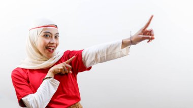 Heyecanlı genç Asyalı kadın Endonezya 'nın bağımsızlık gününü 17 Ağustos' ta kutluyor. Yanındaki fotokopi alanını işaret ediyor.