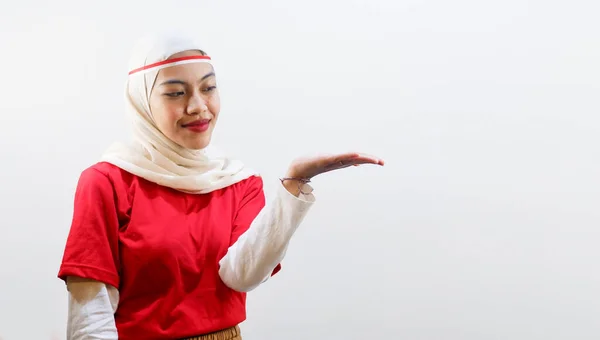 興奮した若いアジアの女性は 彼女の横のコピースペースを指して 8月17日にインドネシアの独立記念日を祝います — ストック写真