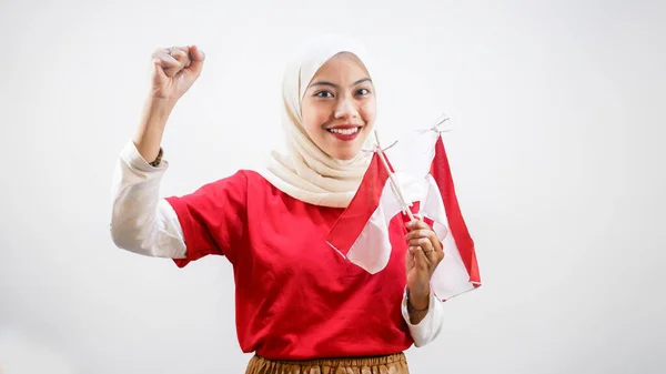 興奮した若いアジアの女性は白い背景に隔離されたインドネシアの旗を保持するインドネシアの独立記念日を祝う — ストック写真