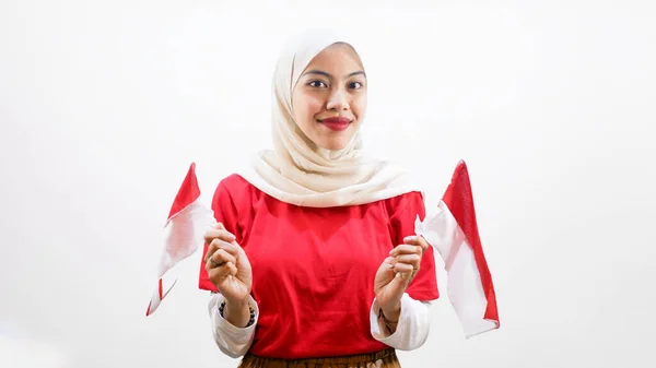 興奮した若いアジアの女性は白い背景に隔離されたインドネシアの旗を保持するインドネシアの独立記念日を祝う — ストック写真