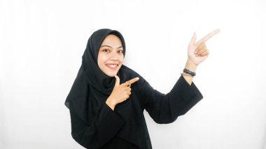 Genç Asyalı kadın farklı yönleri işaret ederek boş fotokopi alanıyla izole edilmiş beyaz arka planda duruyor. İşaret parmağı. Yönlendirme