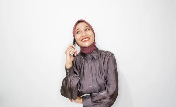 白い背景に対して携帯電話で話している幸せな若いイスラム教徒の女性の肖像画 — ストック写真