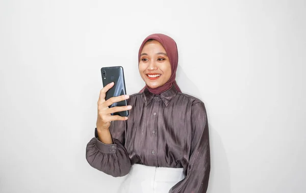 年轻的亚洲穆斯林妇女在白人背景下使用手机的画像 — 图库照片