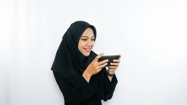自撮りをしている陽気な若いアジアの女性は 白い背景の上に隔離されたスマートフォンのフロントカメラを見て — ストック写真