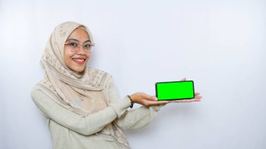 Genç Asyalı kadın telefon ekranında fotokopi alanı gösteriyor. Beyaz arkaplan üzerinde izole edilmiş