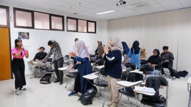 Yogyakarta, Endonezya - 21 Ekim 2023. Sınıfta sınıfa katılan bir grup öğrenci. Eğitim ve öğrenme kavramı.