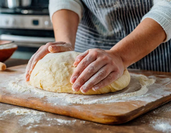 hands of the baker\'s woman knead dough