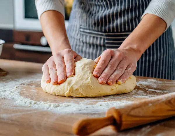 hands of the baker's woman knead dough