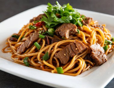 Yakın plan kızarmış yakisoba eriştesi ve sığır eti..