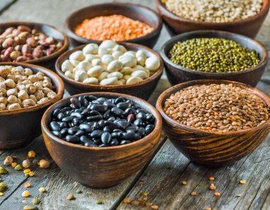 Temel protein kaynaklarını temsil eden çeşitli fasulye ve tahıl taneleri koleksiyonu..