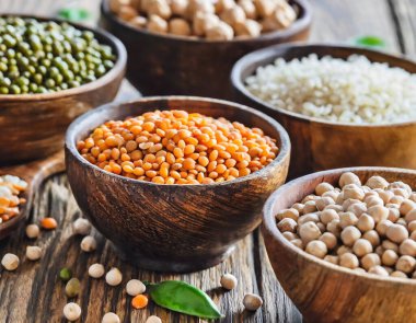Temel protein kaynaklarını temsil eden çeşitli fasulye ve tahıl taneleri koleksiyonu..