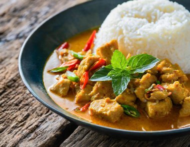 Tayland usulü körili baharatlı domuz eti, sade bir arka planda pirinç ile servis edilir. Tayland mutfağının leziz bir temsili..