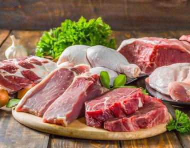 Tahta bir masada sergilenen domuz eti, sığır eti, hindi ve tavuk gibi çeşitli taze etler..