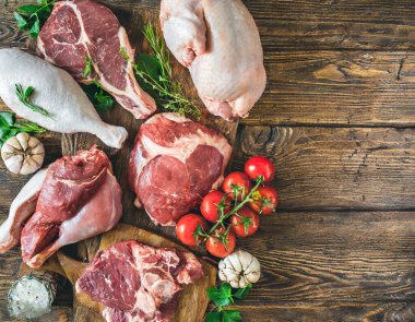 Tahta bir masada sergilenen domuz eti, sığır eti, hindi ve tavuk gibi çeşitli taze etler..