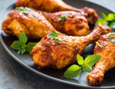 Üst manzara, Hint usulü tandır tavuğu koyu taştan bir arka planda sunuluyor. Tavuk bacakları yoğurt ve baharatla marine edilmiş..