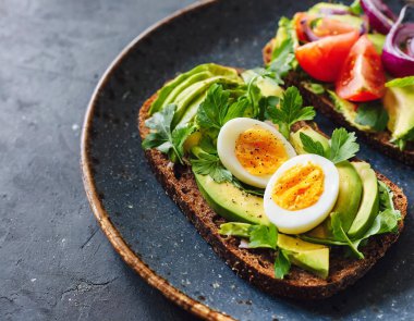 Kavrulmuş yumurta ve avokado püresiyle çıtır çıtır bir tost içeren lezzetli bir kahvaltı veya tapas..
