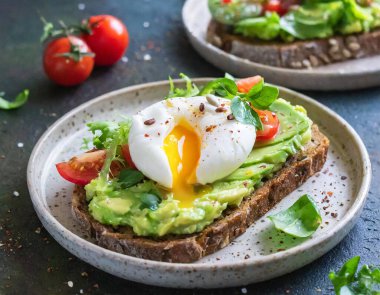 Kavrulmuş yumurta ve avokado püresiyle çıtır çıtır bir tost içeren lezzetli bir kahvaltı veya tapas..