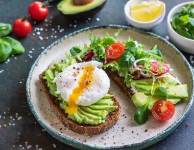 Kavrulmuş yumurta ve avokado püresiyle çıtır çıtır bir tost içeren lezzetli bir kahvaltı veya tapas..
