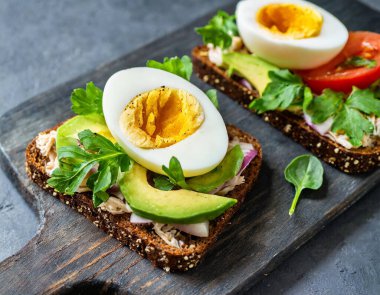 Kavrulmuş yumurta ve avokado püresiyle çıtır çıtır bir tost içeren lezzetli bir kahvaltı veya tapas..