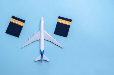 Mavi arka planda izole edilmiş bir uçak modeli ve pilot rütbesi. Bazı düzenlemelerden sonra.