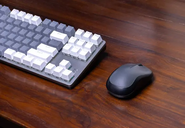 A modern mechanical keyboard and mouse on a wooden table. After some edits.