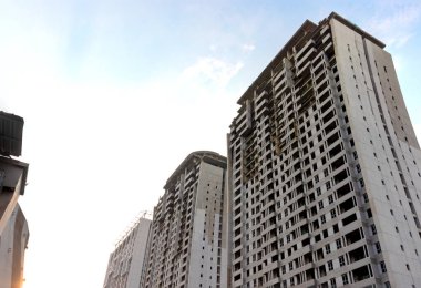 Öğleden sonra mavi gökyüzü arkaplanlı, inşaat halindeki yüksek katlı apartman. Bazı düzenlemelerden sonra.