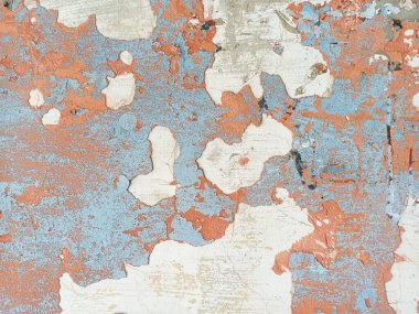 An old wall painted a long time ago with pale blue and terracotta paint with peeling plaster clipart