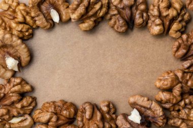 Soyulmuş ceviz kabuğu üst görünümü kahverengi tonda arkaplan ceviz çekirdeği çerçevesi ve bir yazı için bir yer.